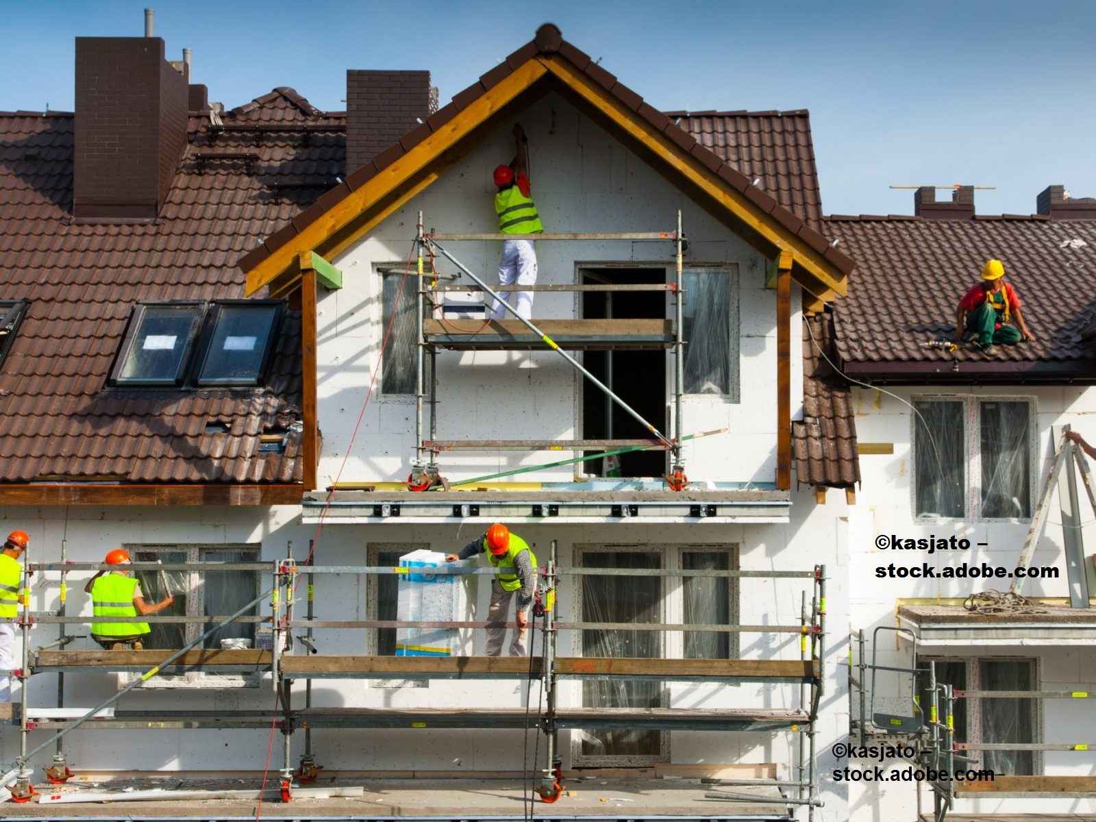 ein Foto mit Bauarbeitern an einem Wohnhaus