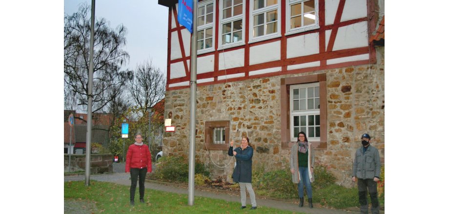 Das Foto zeigt die Bürgermeisterin der Stadt Moringen, die Gleichstellungsbeauftragte sowie Herrn Kellner und Frau Brüggemann vor dem Rathaus beim Fahne hissen 