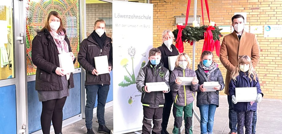 hier sehen Sie vier Kinder der Löwenzahnschule sowie die Schulleitung, den Konrektor, die Leiterin des Hauptamtes und den Fillialleiter der Volksbank in Moringen bei der Spendenübergabe 