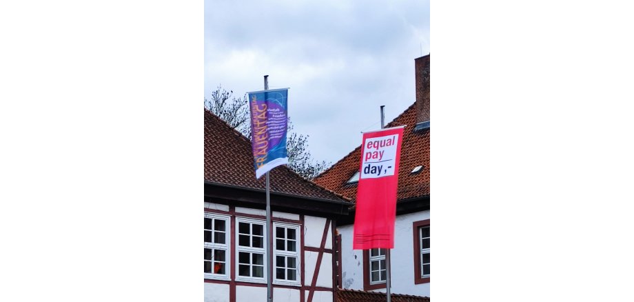 Ein Foto von den Fahnen zum  Internationalen Frauentag und dem Equal-Pay-Day vor dem Moringen Rathaus