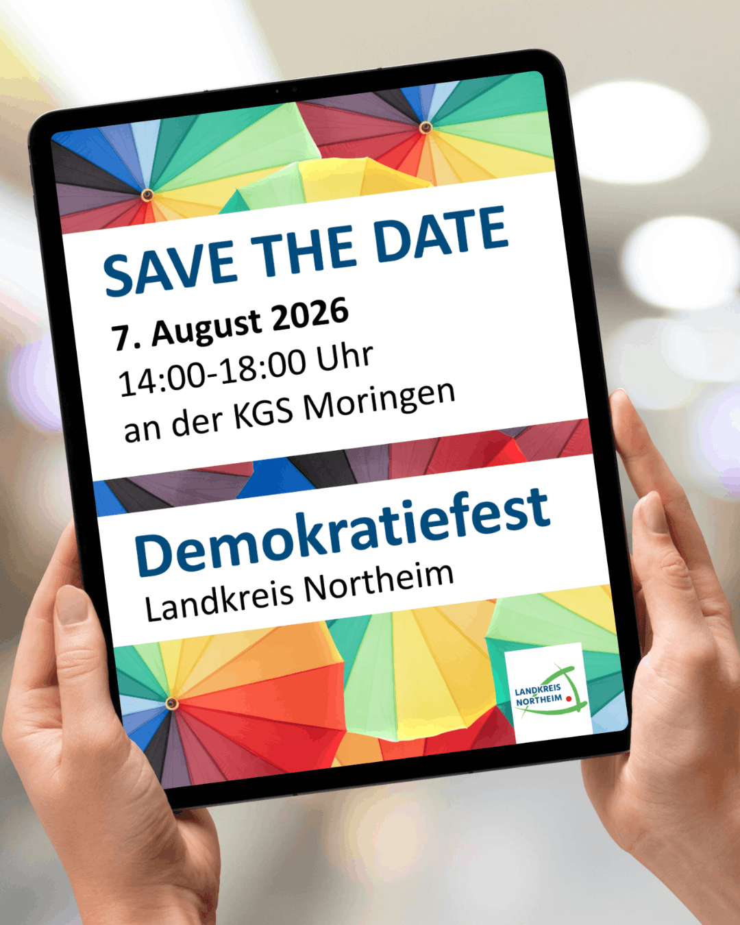 Ein Tablett das mit zwei Händen gehalten wird, wo drauf steht das am 07 August Demokratiefest stattfindet