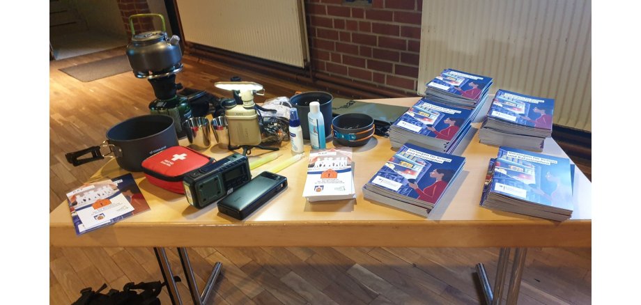 Tisch mit Hilfsmitteln und Broschüren zur Notfallvorsorge Tisch mit Hilfsmitteln und Broschüren zur Notfallvorsorge