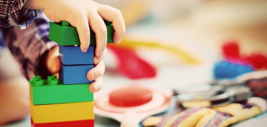 Hier sehen Sie ein Bild eines spielenden Kindes mit Duplo