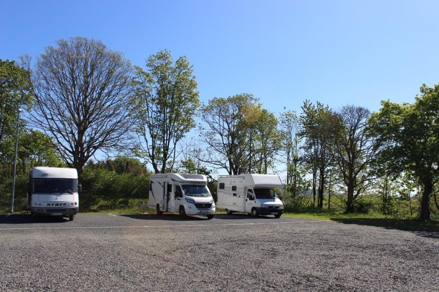 Das Bild zeigt den Wohnmobilstellplatz in Fredelsloh. Dre Wohnmobile sind zu sehen.